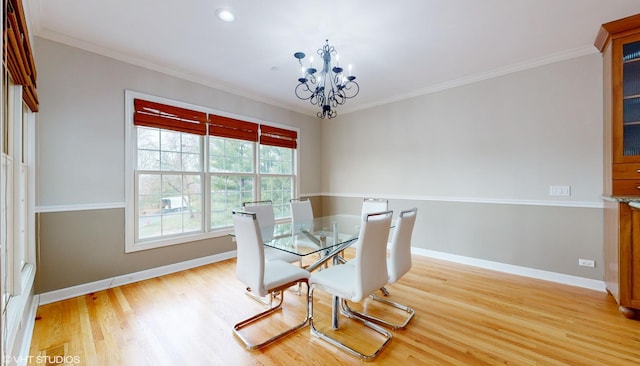 dining space featuring light wood-type flooring, an inviting chandelier, and crown molding