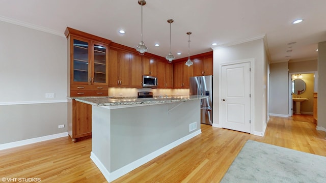 kitchen with pendant lighting, a center island, light wood-type flooring, light stone counters, and stainless steel appliances