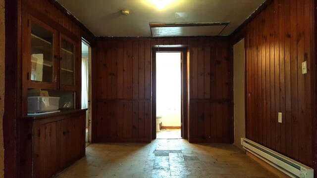 interior space with a baseboard radiator and wooden walls