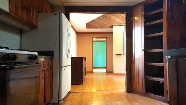 hall with light wood-style floors and baseboards