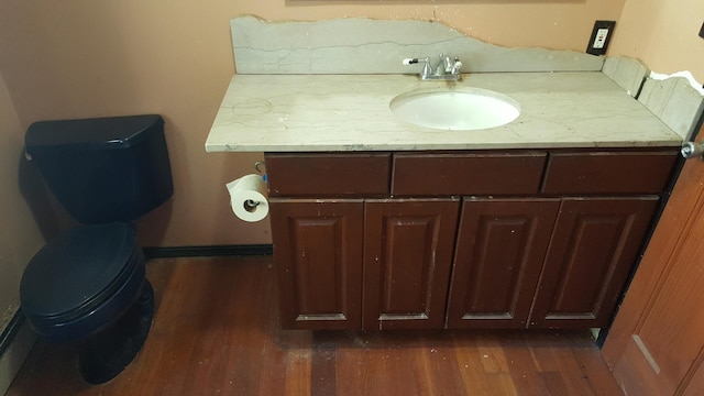 bathroom featuring toilet, wood finished floors, and vanity