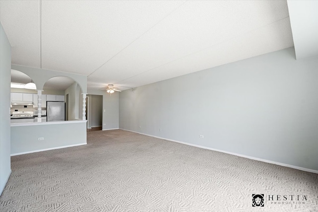 unfurnished living room featuring ceiling fan and light carpet