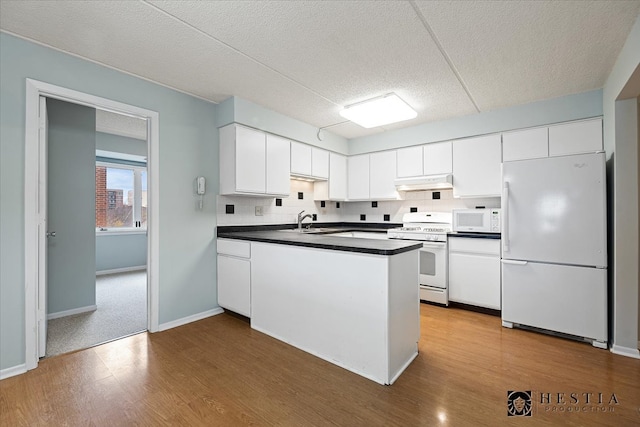 kitchen featuring white appliances, sink, light wood-type flooring, a textured ceiling, and white cabinetry