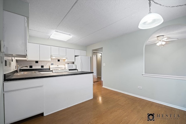 kitchen with white appliances, ceiling fan, sink, pendant lighting, and white cabinets