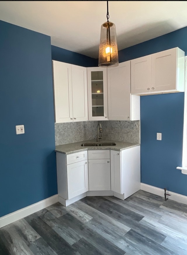 kitchen featuring white cabinets, pendant lighting, sink, and tasteful backsplash