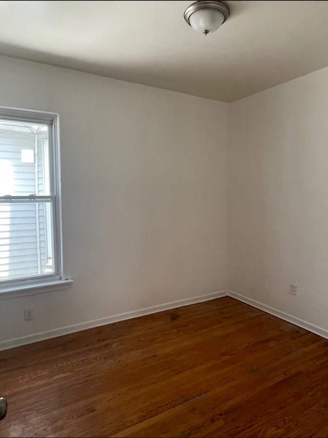 spare room with dark wood-type flooring