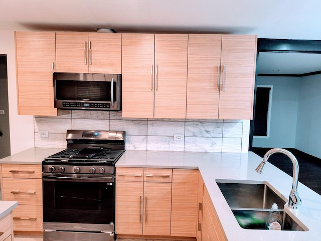 kitchen featuring light brown cabinets, sink, stainless steel appliances, and tasteful backsplash