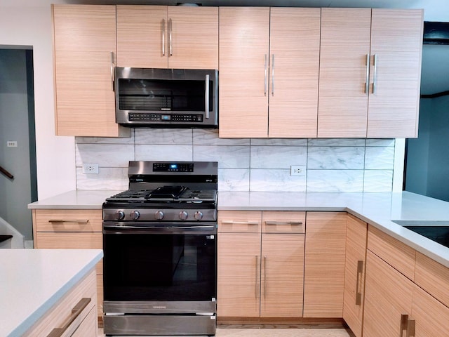 kitchen featuring light brown cabinetry, backsplash, and appliances with stainless steel finishes