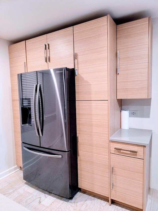 kitchen featuring stainless steel fridge with ice dispenser, light brown cabinets, and light hardwood / wood-style flooring