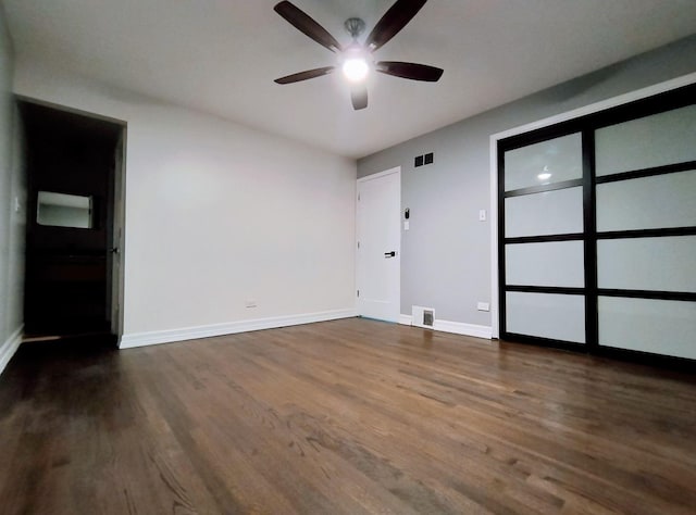 unfurnished bedroom with ceiling fan and dark hardwood / wood-style flooring