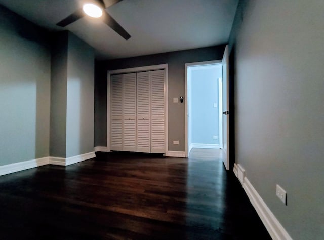 unfurnished bedroom featuring ceiling fan, dark hardwood / wood-style flooring, and a closet