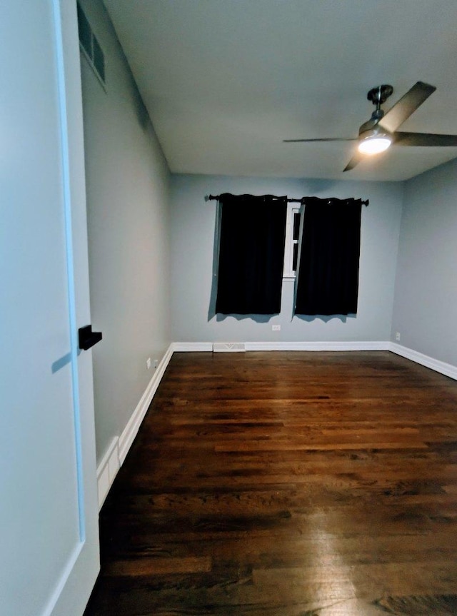 unfurnished room featuring ceiling fan and dark wood-type flooring