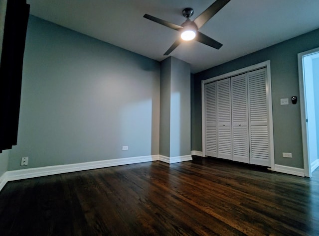 unfurnished bedroom featuring ceiling fan, dark hardwood / wood-style flooring, and a closet