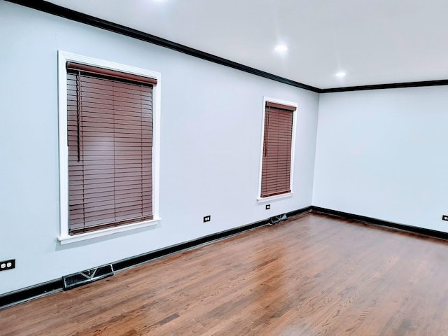 empty room with crown molding and hardwood / wood-style floors