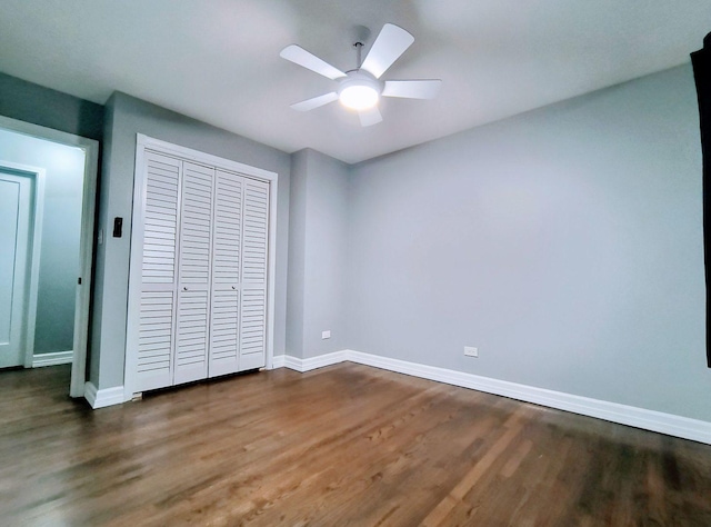 unfurnished bedroom featuring ceiling fan, dark hardwood / wood-style flooring, and a closet