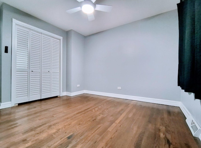 unfurnished bedroom featuring hardwood / wood-style floors, ceiling fan, and a closet