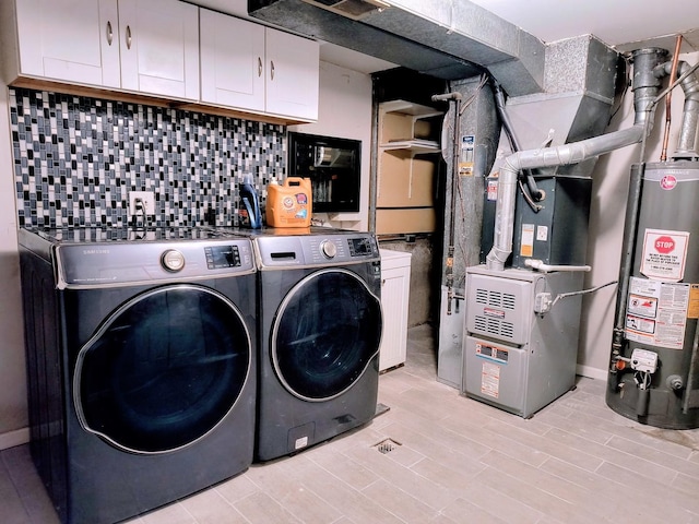 laundry room featuring cabinets, independent washer and dryer, heating unit, and water heater