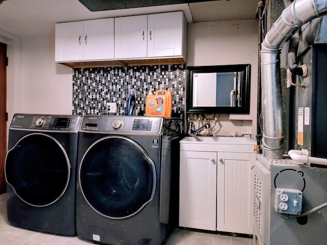 clothes washing area featuring separate washer and dryer, sink, and cabinets