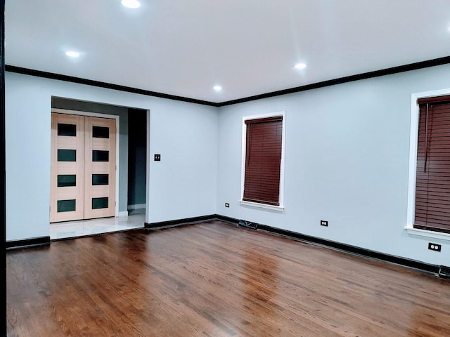 spare room featuring hardwood / wood-style floors and crown molding