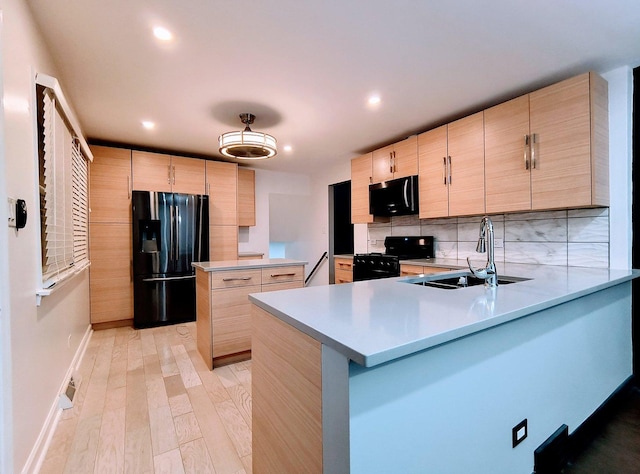 kitchen with kitchen peninsula, light brown cabinetry, decorative backsplash, and black appliances