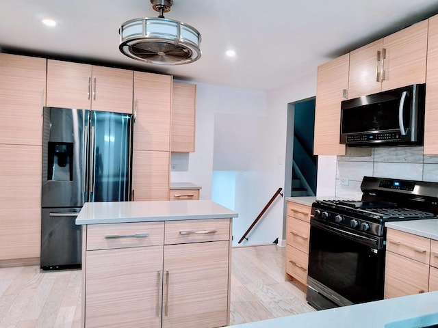 kitchen with gas stove, light brown cabinets, refrigerator with ice dispenser, and light wood-type flooring