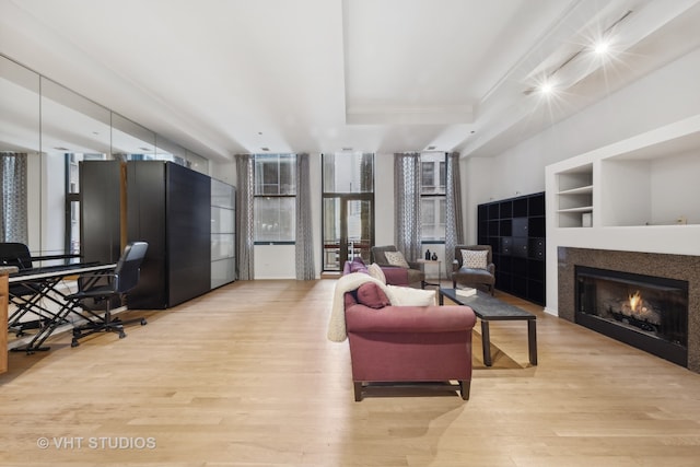 living room featuring built in features and light hardwood / wood-style flooring