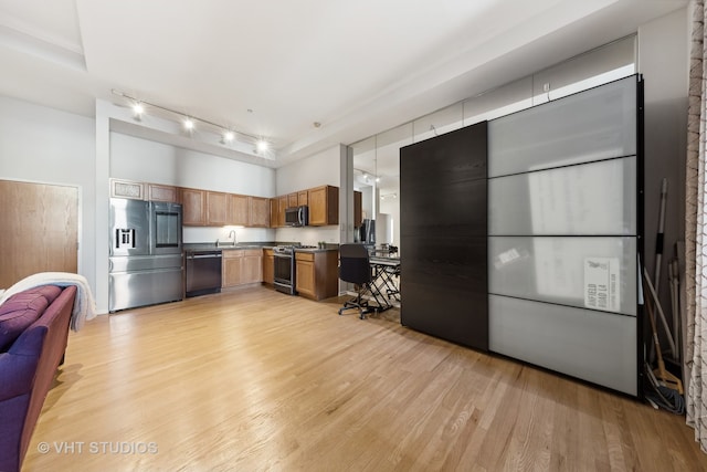 kitchen with light hardwood / wood-style floors, sink, appliances with stainless steel finishes, and track lighting