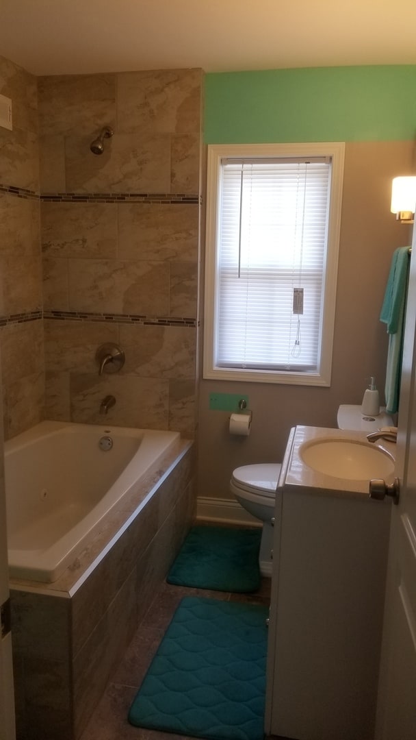 full bathroom featuring vanity, toilet, and tiled shower / bath combo