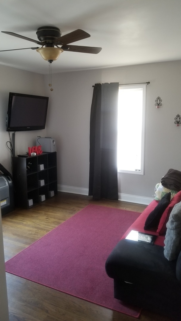 living room featuring hardwood / wood-style flooring and ceiling fan