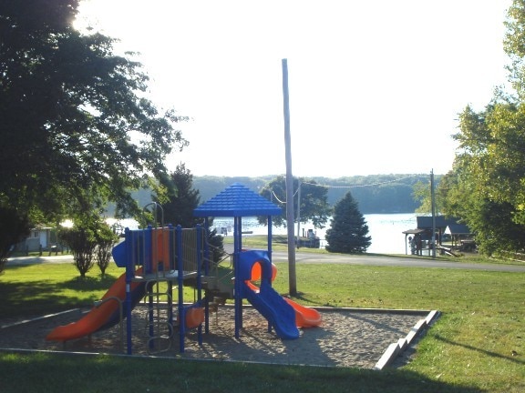 view of play area with a lawn and a water view