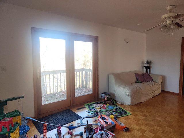 living room with ceiling fan and parquet floors