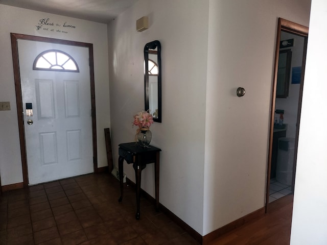 foyer entrance with dark tile patterned floors