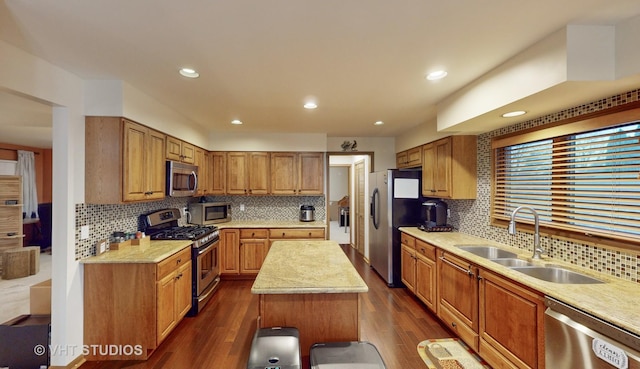 kitchen with decorative backsplash, dark hardwood / wood-style flooring, stainless steel appliances, sink, and a kitchen island