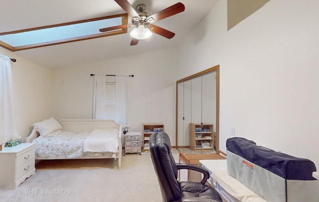 carpeted bedroom with lofted ceiling with skylight, a closet, and ceiling fan