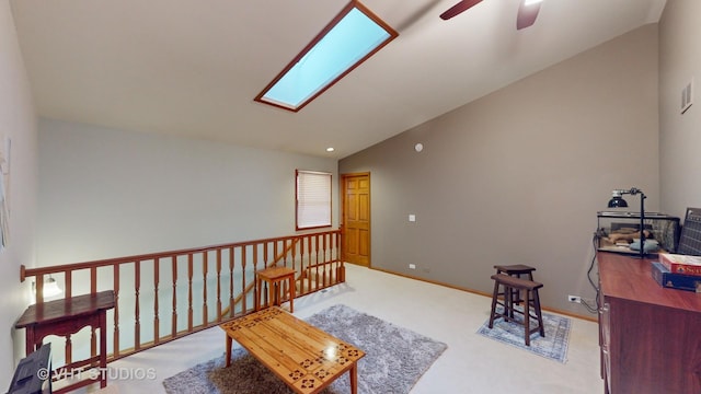 sitting room featuring a skylight, ceiling fan, carpet floors, and high vaulted ceiling