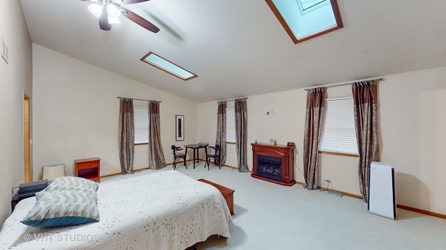 bedroom featuring carpet flooring, ceiling fan, and vaulted ceiling with skylight