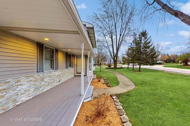 wooden deck featuring a lawn