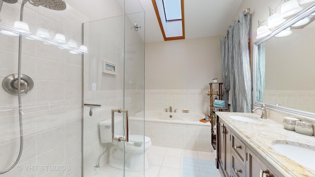 full bathroom featuring vanity, plus walk in shower, a skylight, tile patterned flooring, and toilet