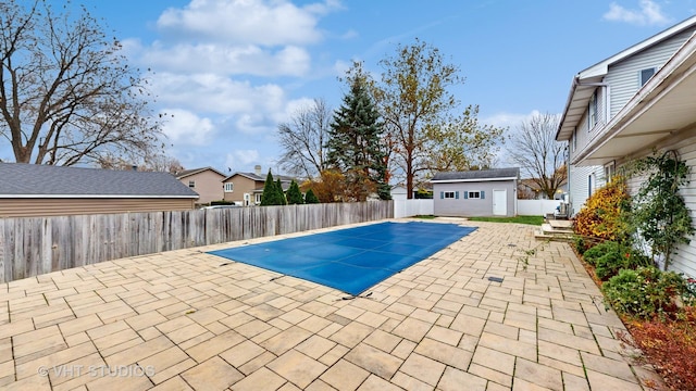 view of pool featuring an outbuilding and a patio