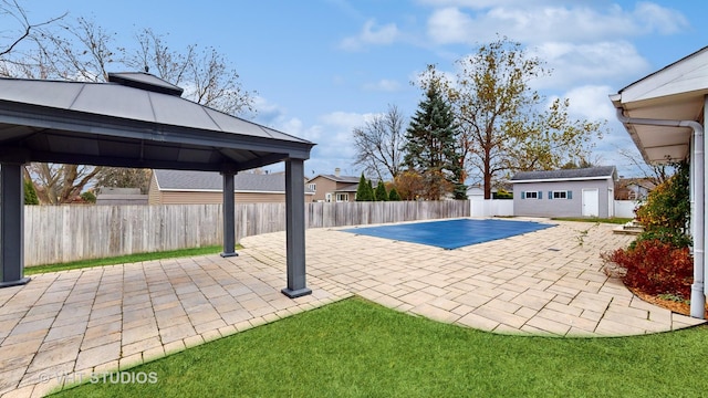 view of pool with a gazebo, an outdoor structure, and a patio