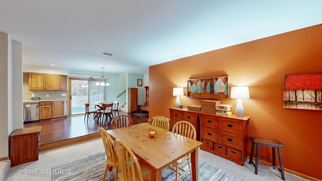 dining room with light carpet and an inviting chandelier