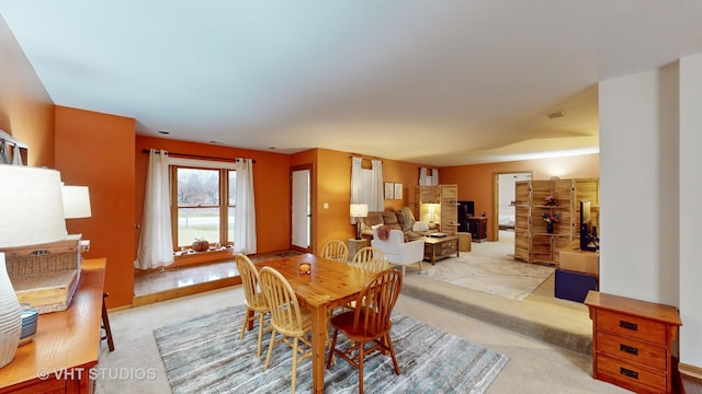 carpeted dining room with a fireplace