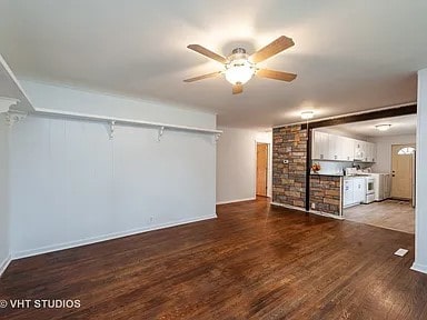 unfurnished living room with ceiling fan and dark wood-type flooring