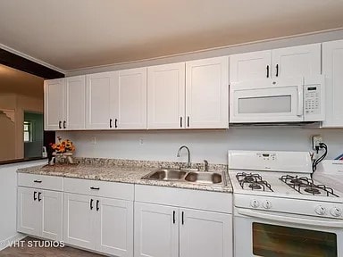 kitchen with white cabinets, white appliances, sink, and ornamental molding