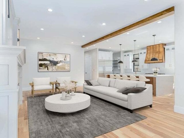 kitchen featuring light hardwood / wood-style floors, white cabinetry, an island with sink, and stainless steel appliances