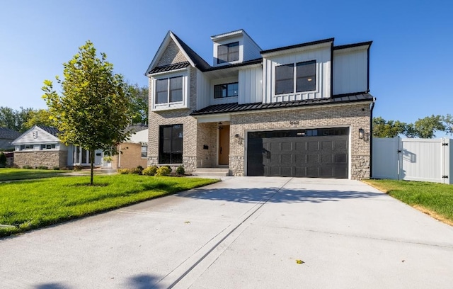 view of front of home with a standing seam roof, driveway, an attached garage, a gate, and stone siding