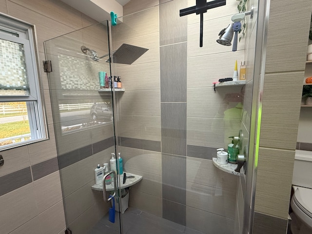 bathroom with toilet and a shower with door