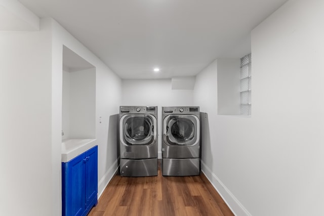 laundry room with dark hardwood / wood-style flooring and washing machine and clothes dryer