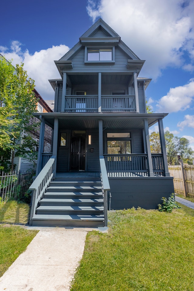 view of front of house with a balcony, a front lawn, and a porch