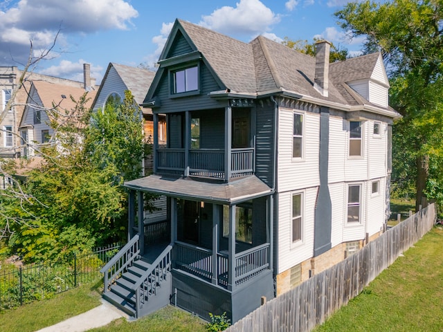 rear view of property with a balcony and covered porch